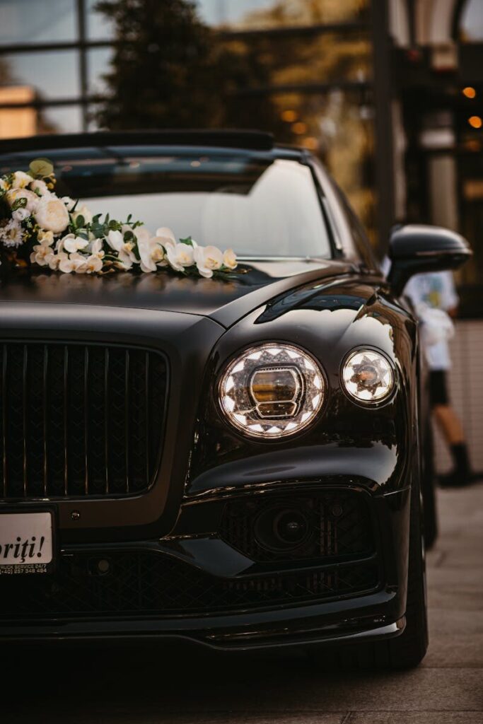 Elegant black luxury car adorned with flowers, parked outdoors in Arad, Romania.