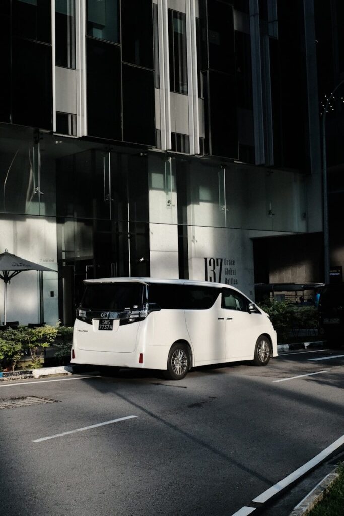 a white bus parked in front of a tall building